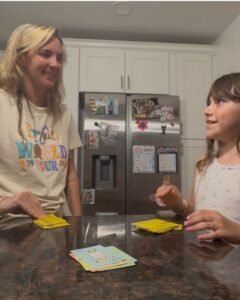 Mom and daughter playing Taco Cat Goat Cheese Pizza card game together at home
